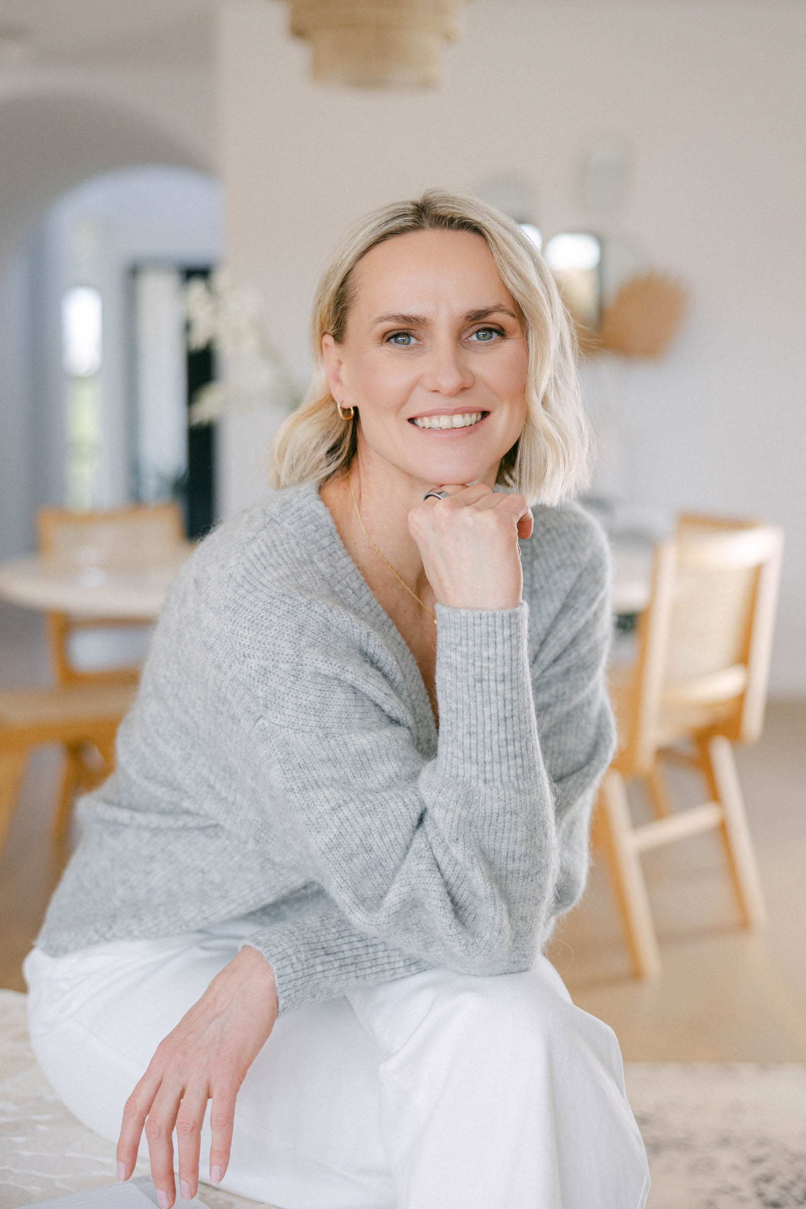 Zelda Green, business and money mentor looking happy and relaxed in a grey jumper