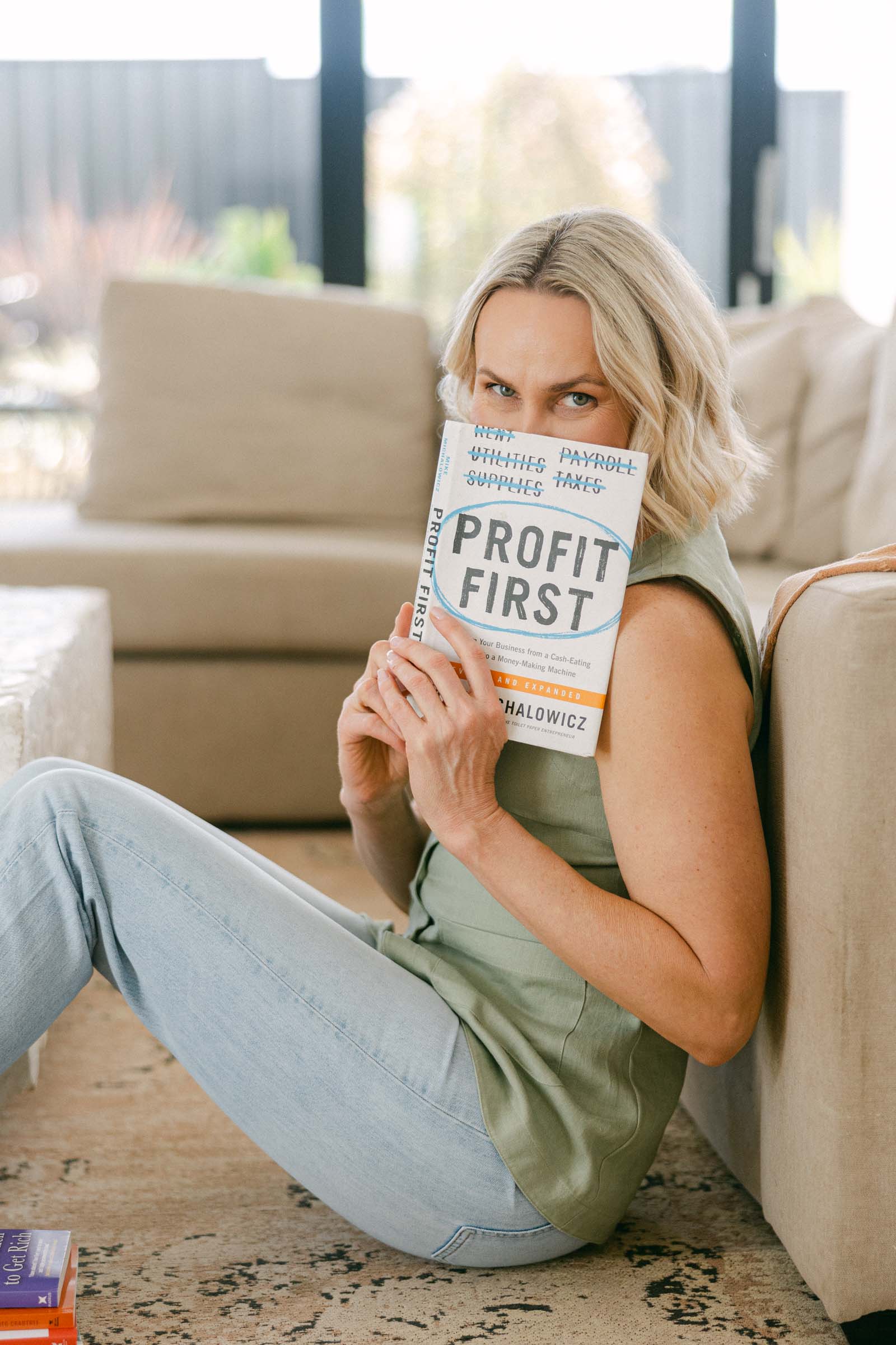 Zelda Green, financial educator, money mindset mentor and business coach holding up the book Profit First